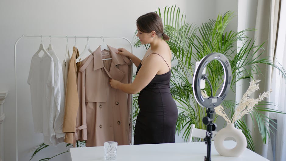 Woman in black dress arranging clothes on a rack for online selling with ring light.