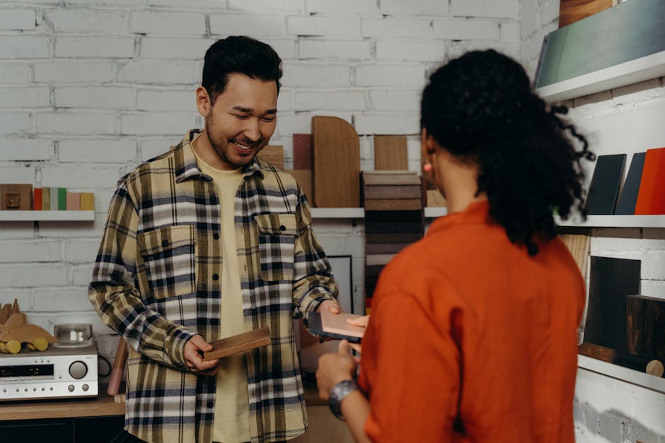 A salesman in a showroom helps a customer with wood samples, showcasing a selection of materials.