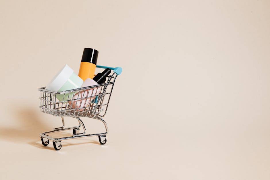 A minimalist image of a mini shopping cart filled with cosmetics on a beige background, ideal for e-commerce concepts.