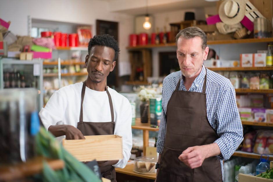 Two male employees organizing products in a cozy grocery store.